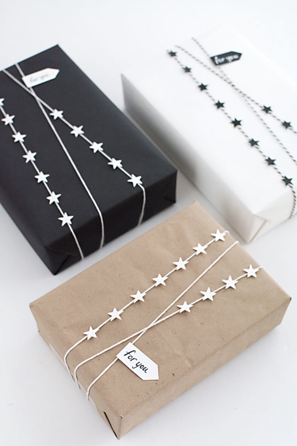 White and black and brown paper decorated with a garland made of twig and small cut-out stars.<span class="sr-only"> (opened in a new window/tab)</span>