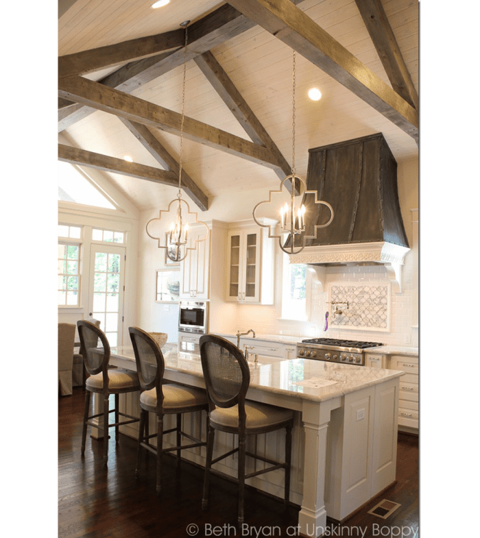 Kitchen with white ceiling and wooden truss vault.