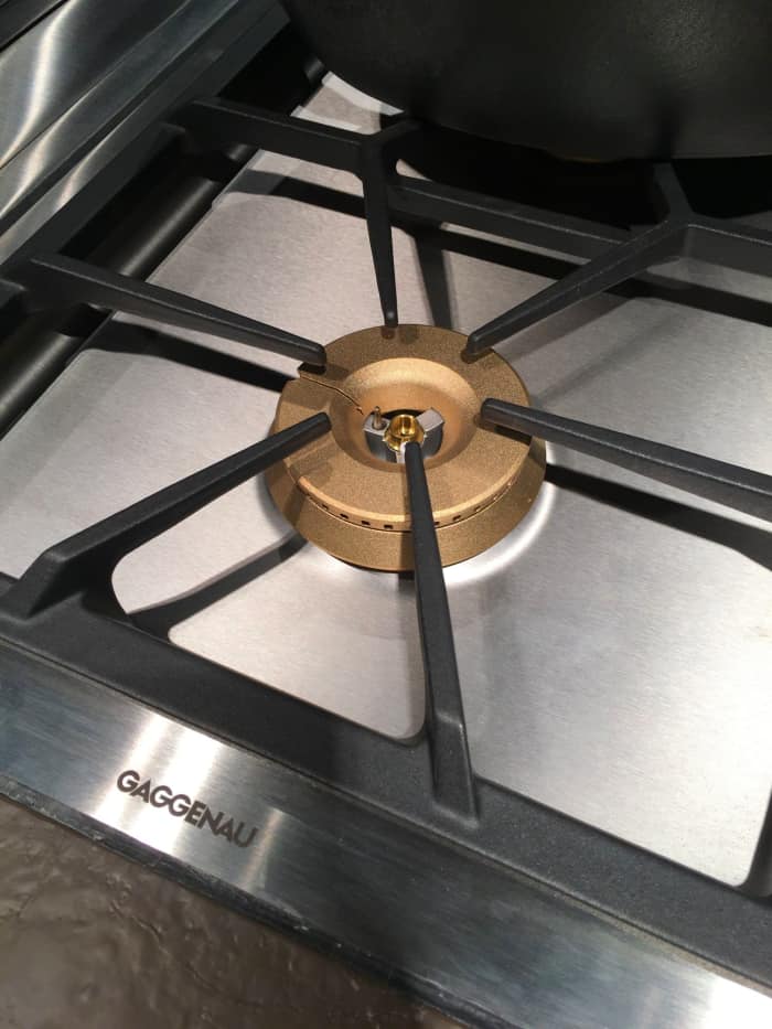 Gold burner covers on a gas cooktop.