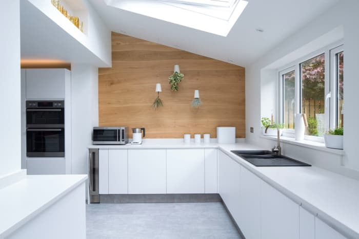 Total white kitchen design with feature wall covered with Bolefloor curved boards.
