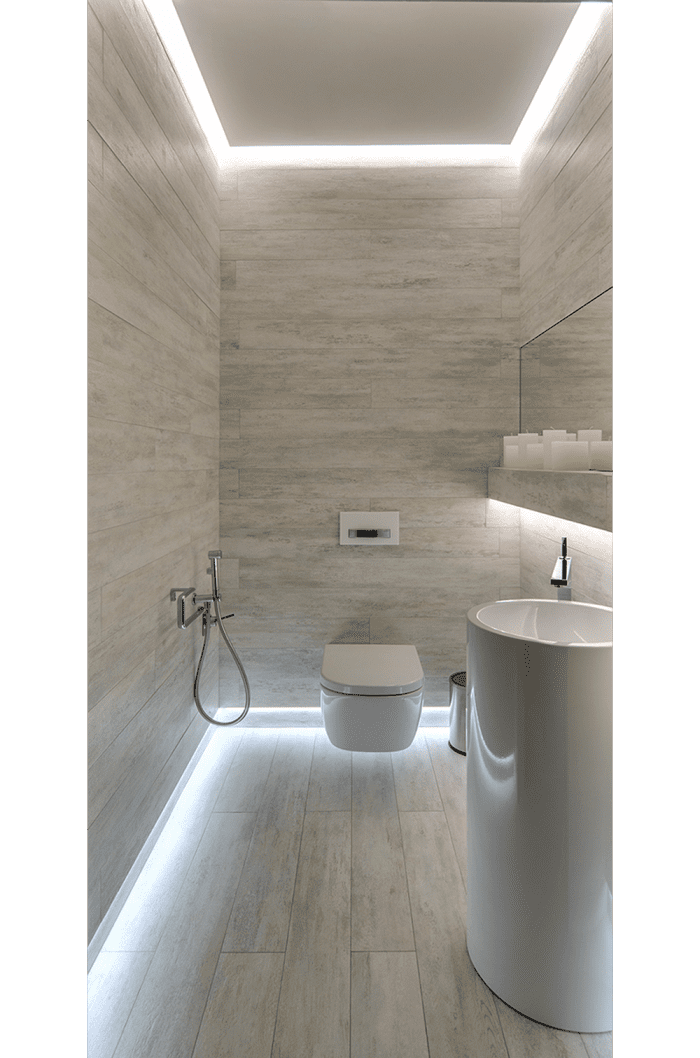 Bathroom with light running all around the perimeter of the room. The lighting body is hidden so all is visible is a light aura.