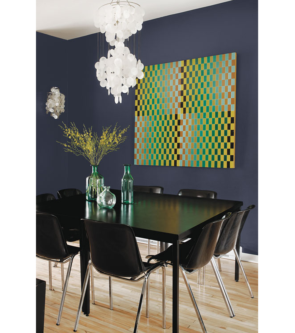 Dining area with black furniture. Back wall painted in Black Flame (2018 colour of the year by PPG paints). The big artwork in the tones of green, yellow and black matches with the vases on the table.
