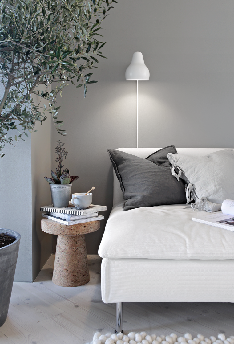 Sofa with soft cushions, a tea and few plants.