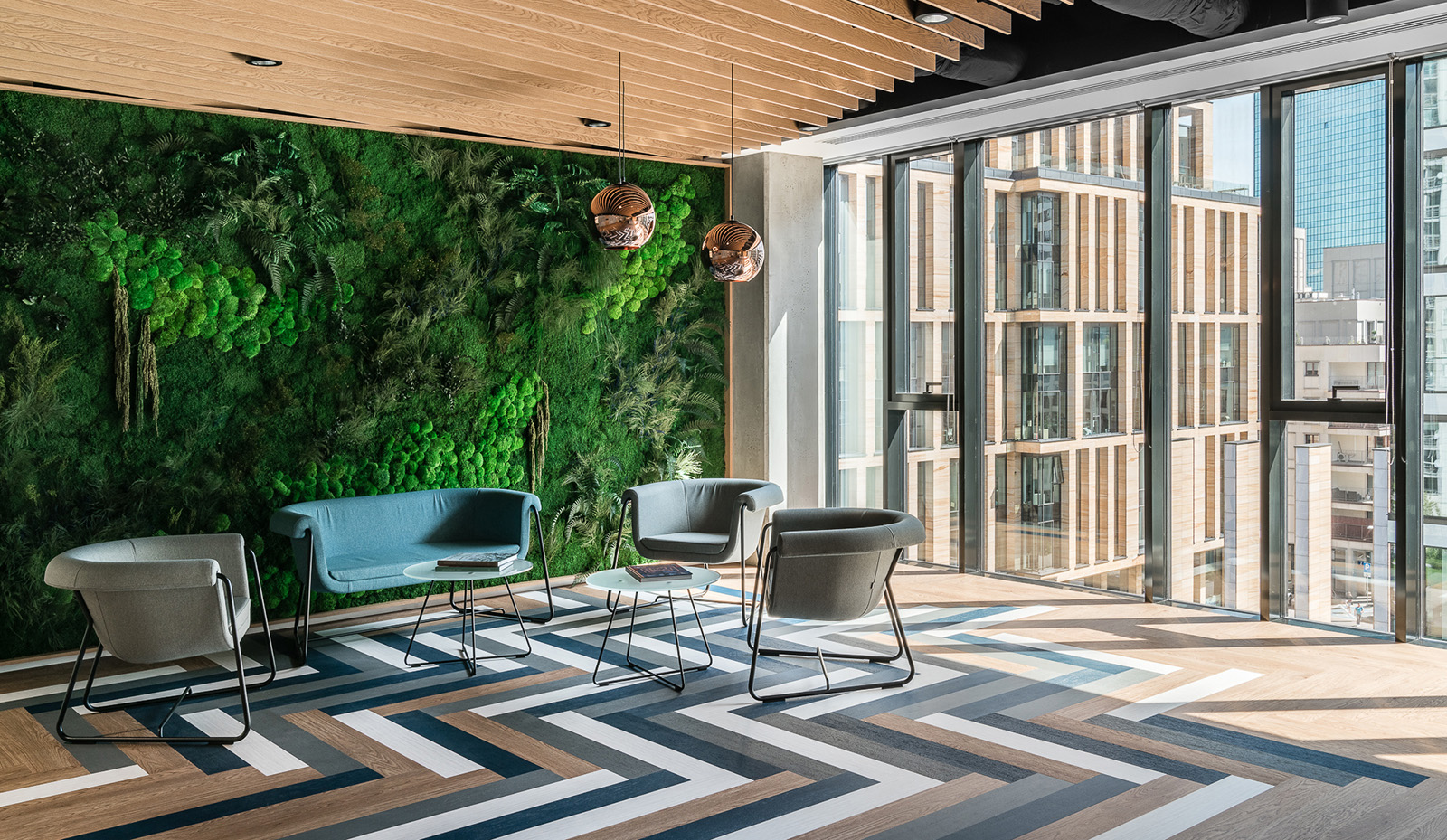 View of a biophilic office sitting area with a vertical garden wall behind it.