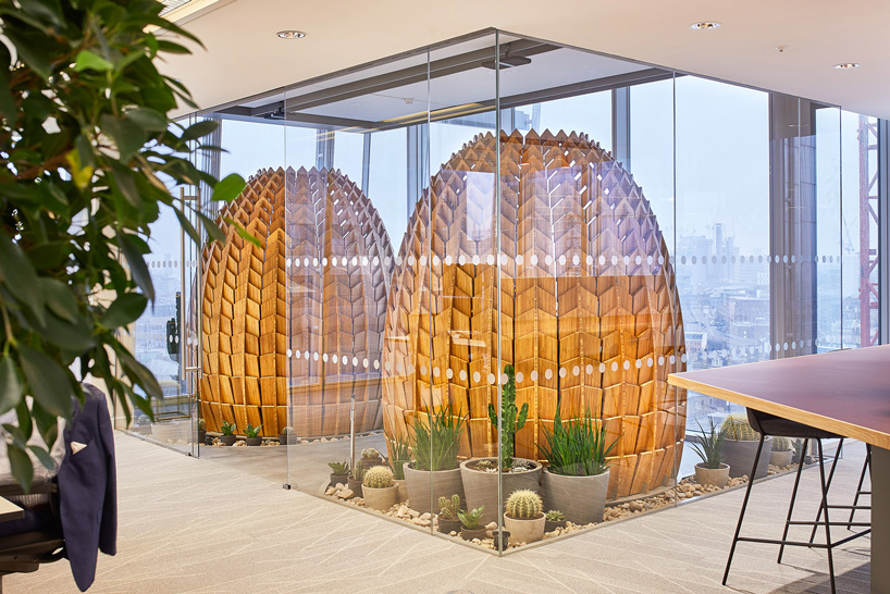Wooden retreat pods in a biophilic office with a shape that recalls a pinecone.