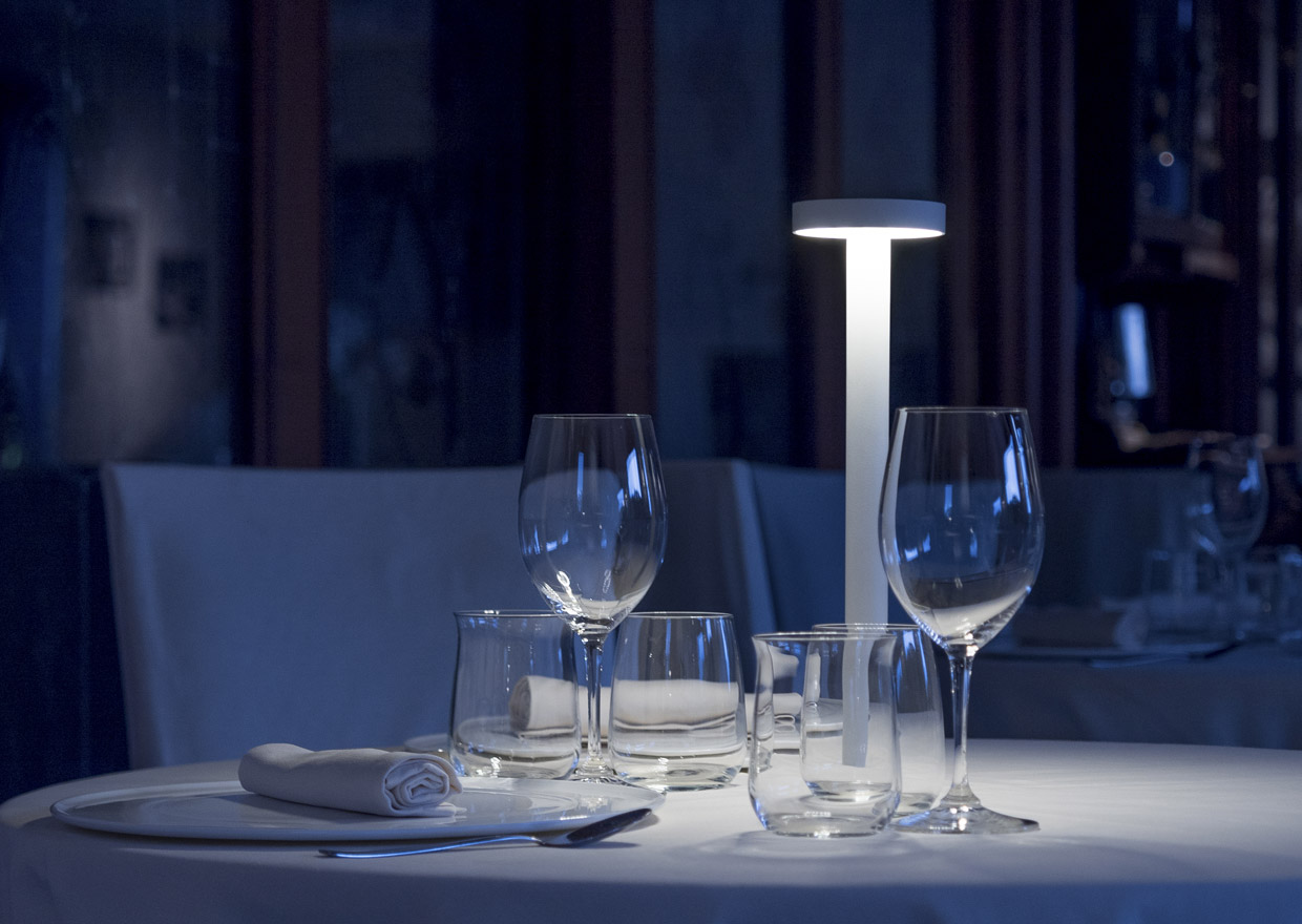 Portable table lamp creating a romantic atmosphere on a dining table.