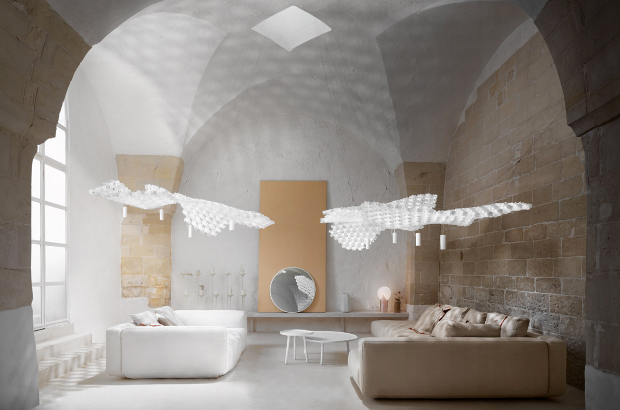 Huge pendant light over a sofa. Its draping look is achieved with individual white modules interlocked.