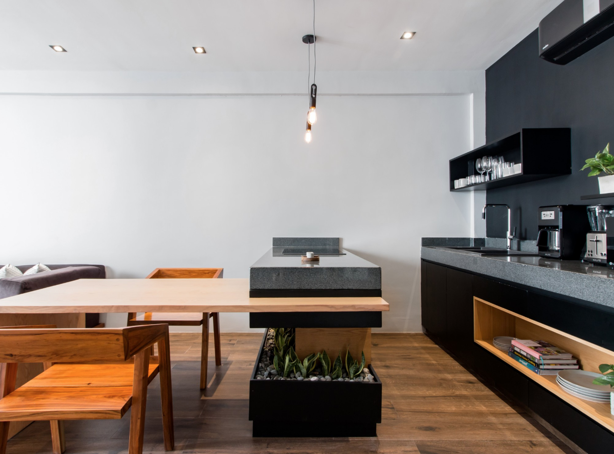 In this minimal apartment, a built-in planter wraps around the kitchen island, creating the perfect spot for plants.