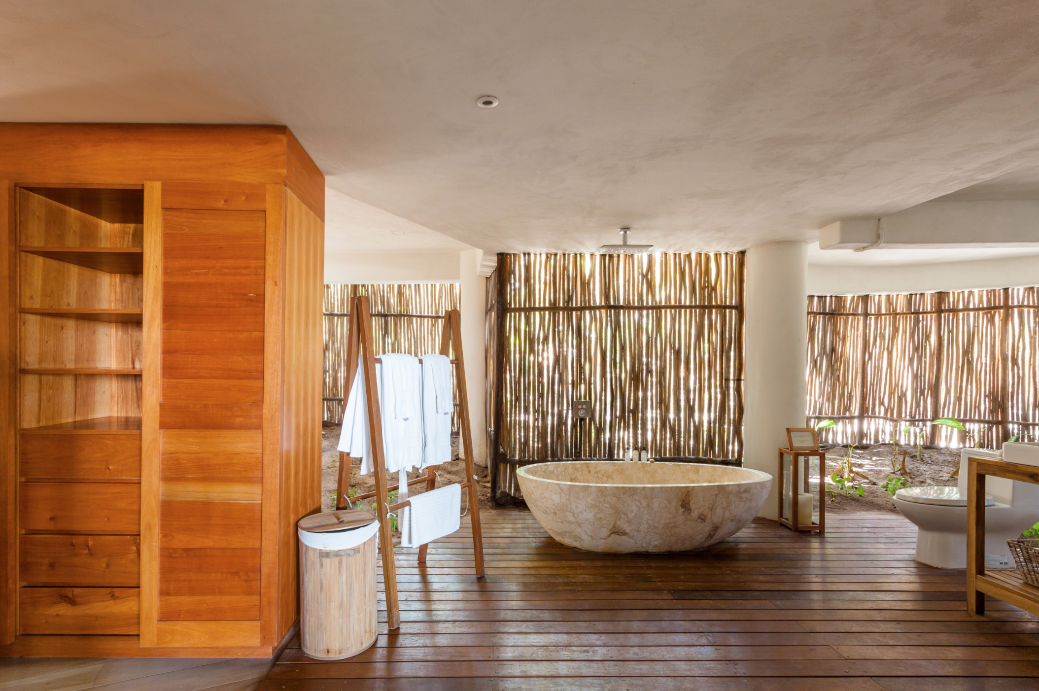 Bathroom of Casa Nalum: the wall is made of bamboo canes that let plenty of natural light in.