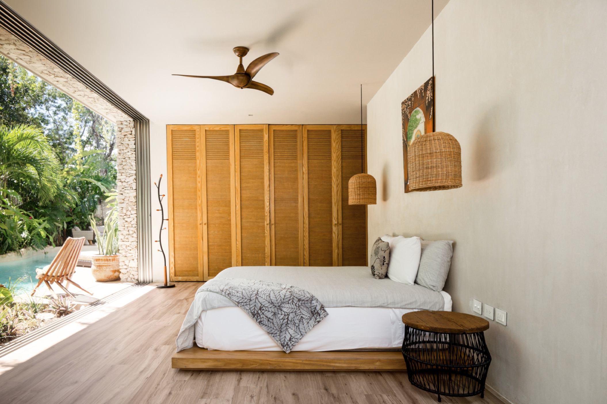 One of the bedrooms of Villa Verde, with a floor-to-ceiling window in front of the bed.