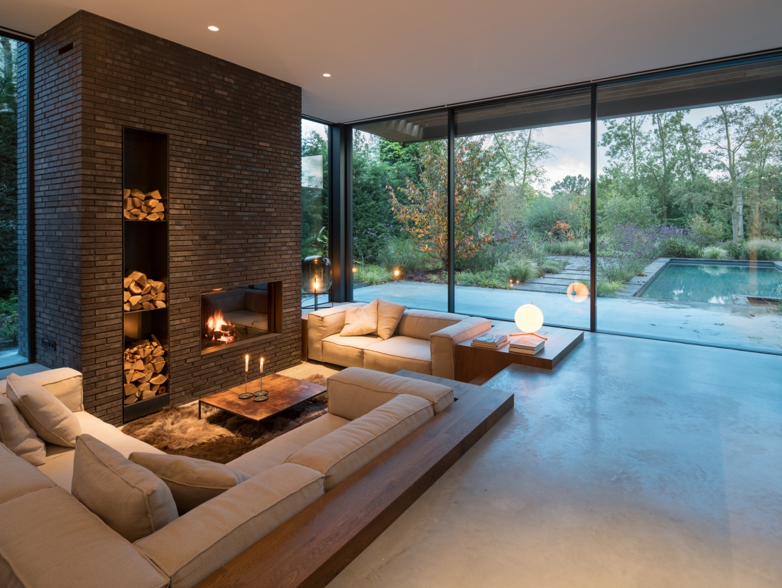 Biophilic living room with big windows leaving the view to the outside totally open.