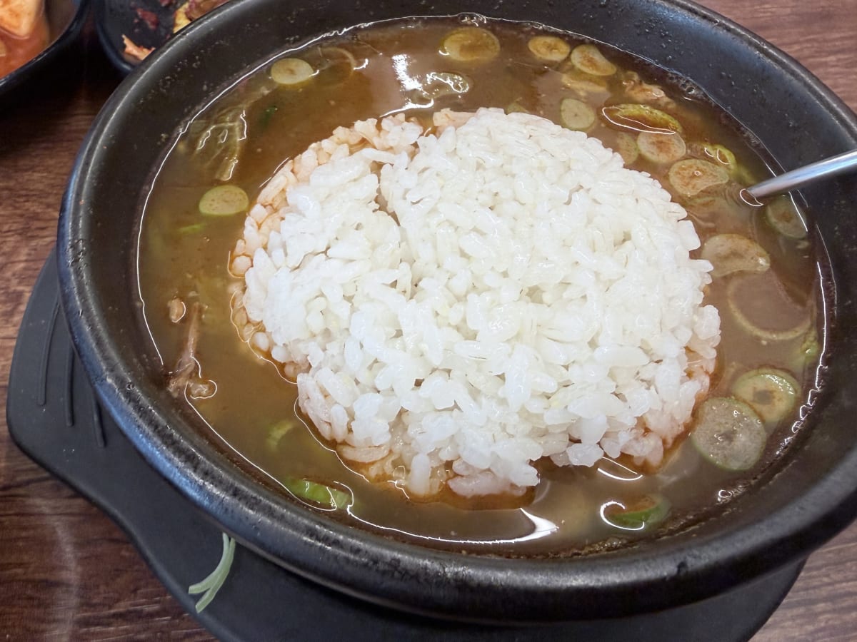 우두육미 장터국밥 밥 말아진 것 — 국물이 밥알 사이로 촤악