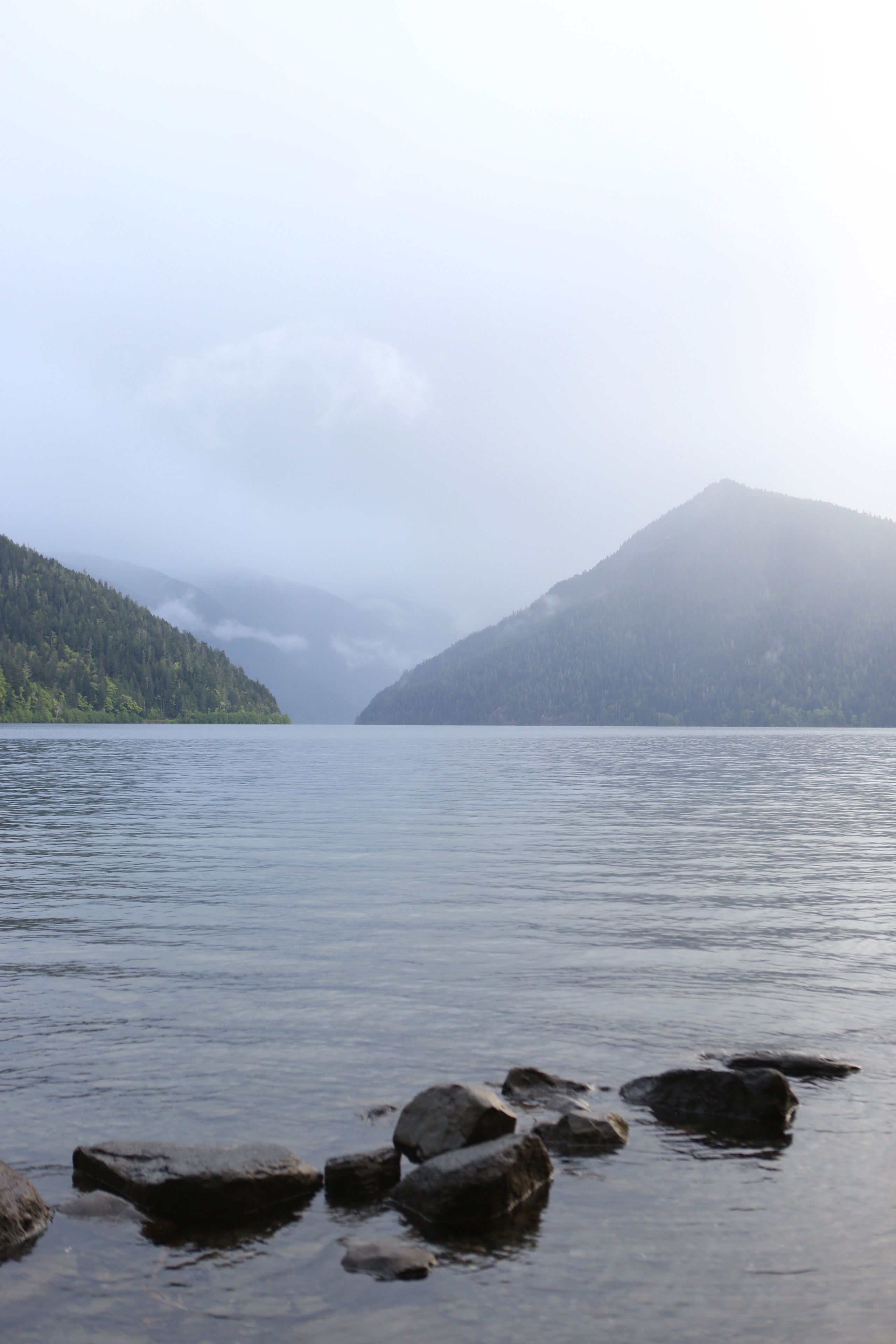 Misty mountains rising over the deep blue water of Lake Crescent in Olympic National Park, Washington