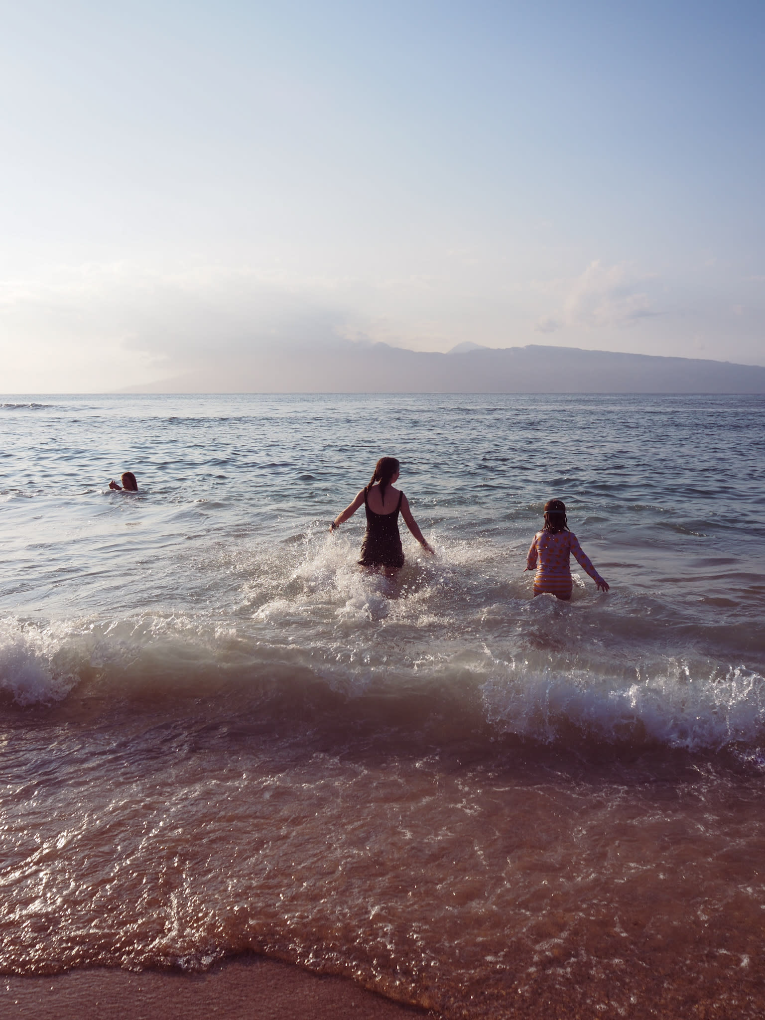 children playing in the waves