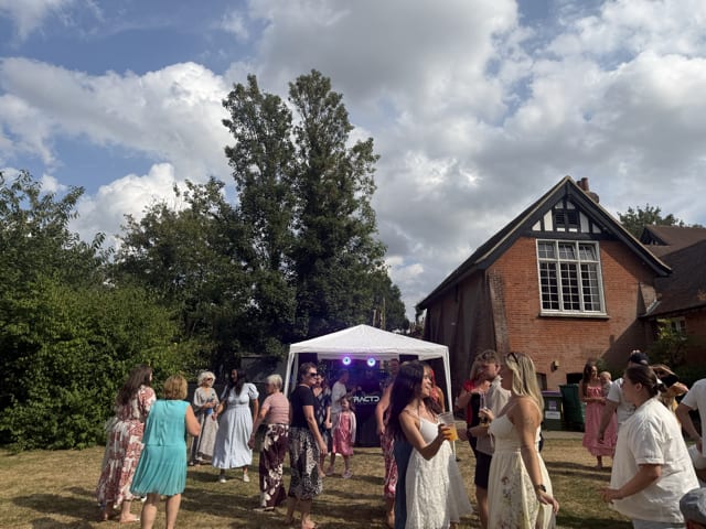 Guests dancing and celebrating outdoors at a sunny DFRACTD garden party