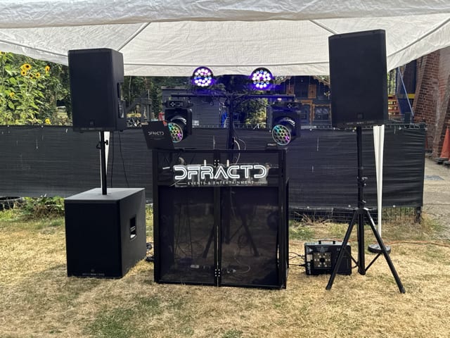 RCF speakers, subwoofer, moving head lights and DJ booth set up ready for an event