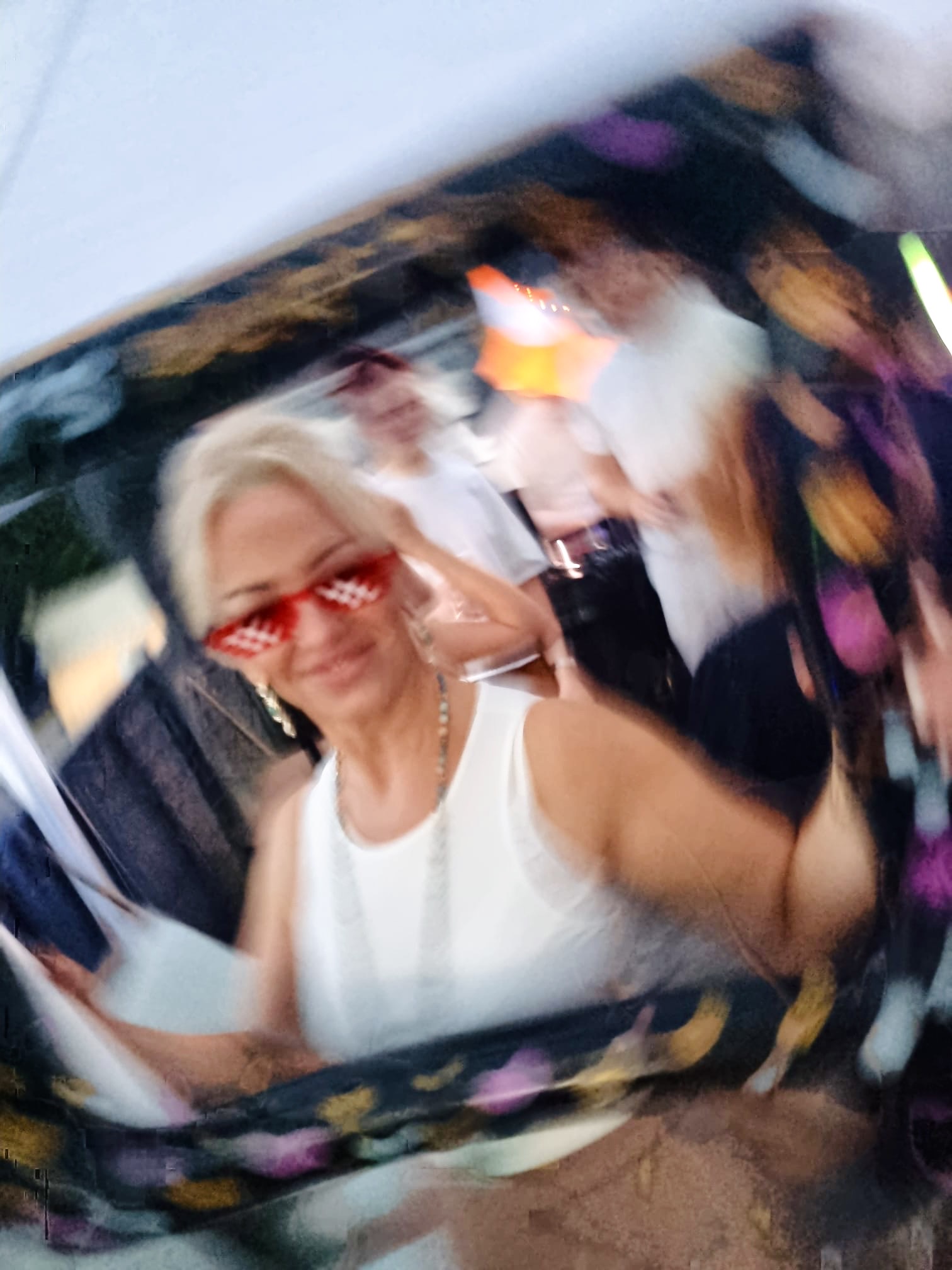 A guest celebrating with heart-shaped sunglasses at a DFRACTD party
