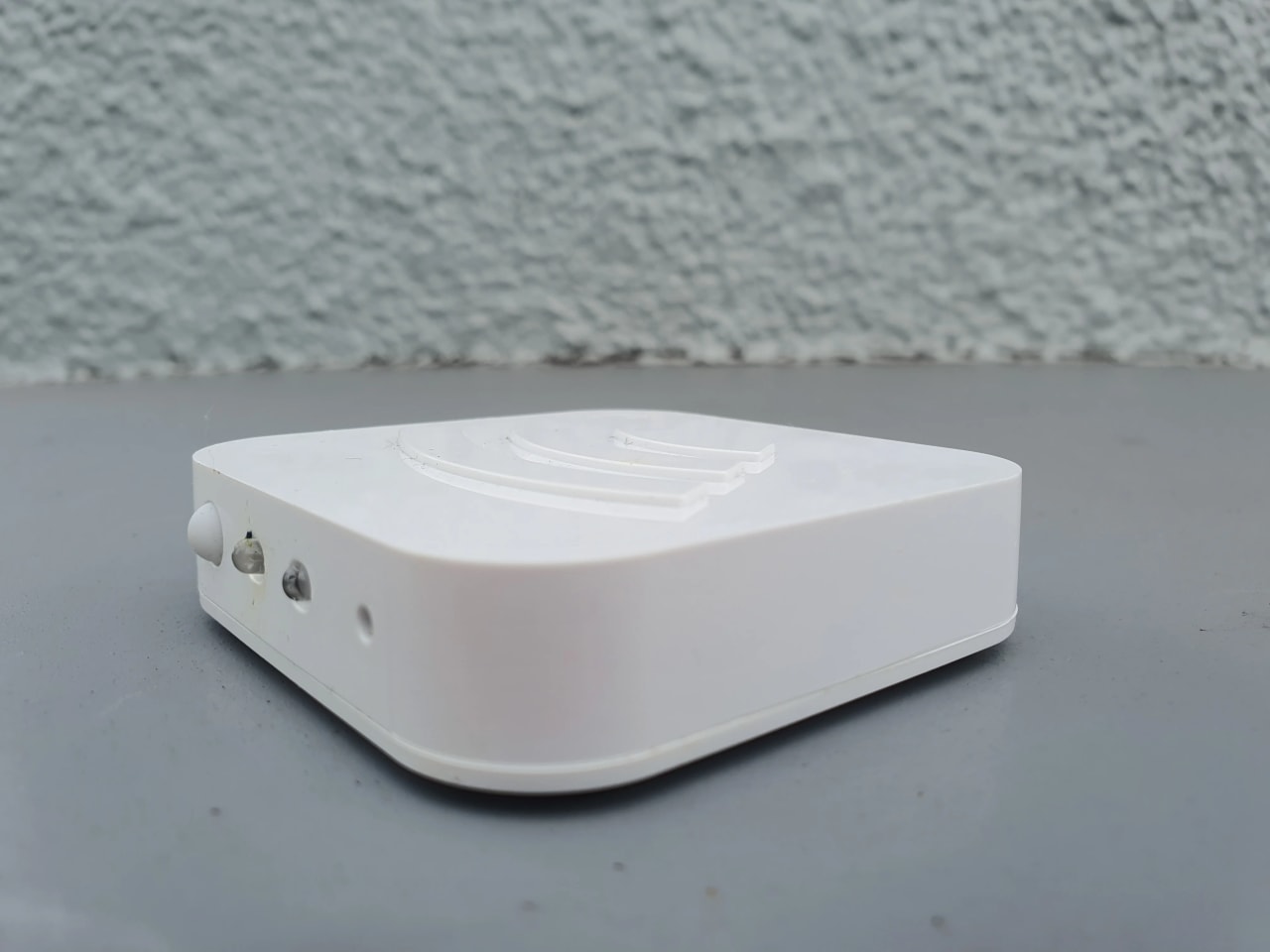 Controlador infravermelho Wi-Fi sobre a mesa, usado como referência visual para automação IR e RF