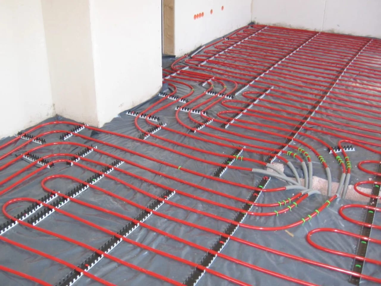 Tubulações de piso aquecido instaladas antes do contrapiso, representando aquecimento radiante residencial