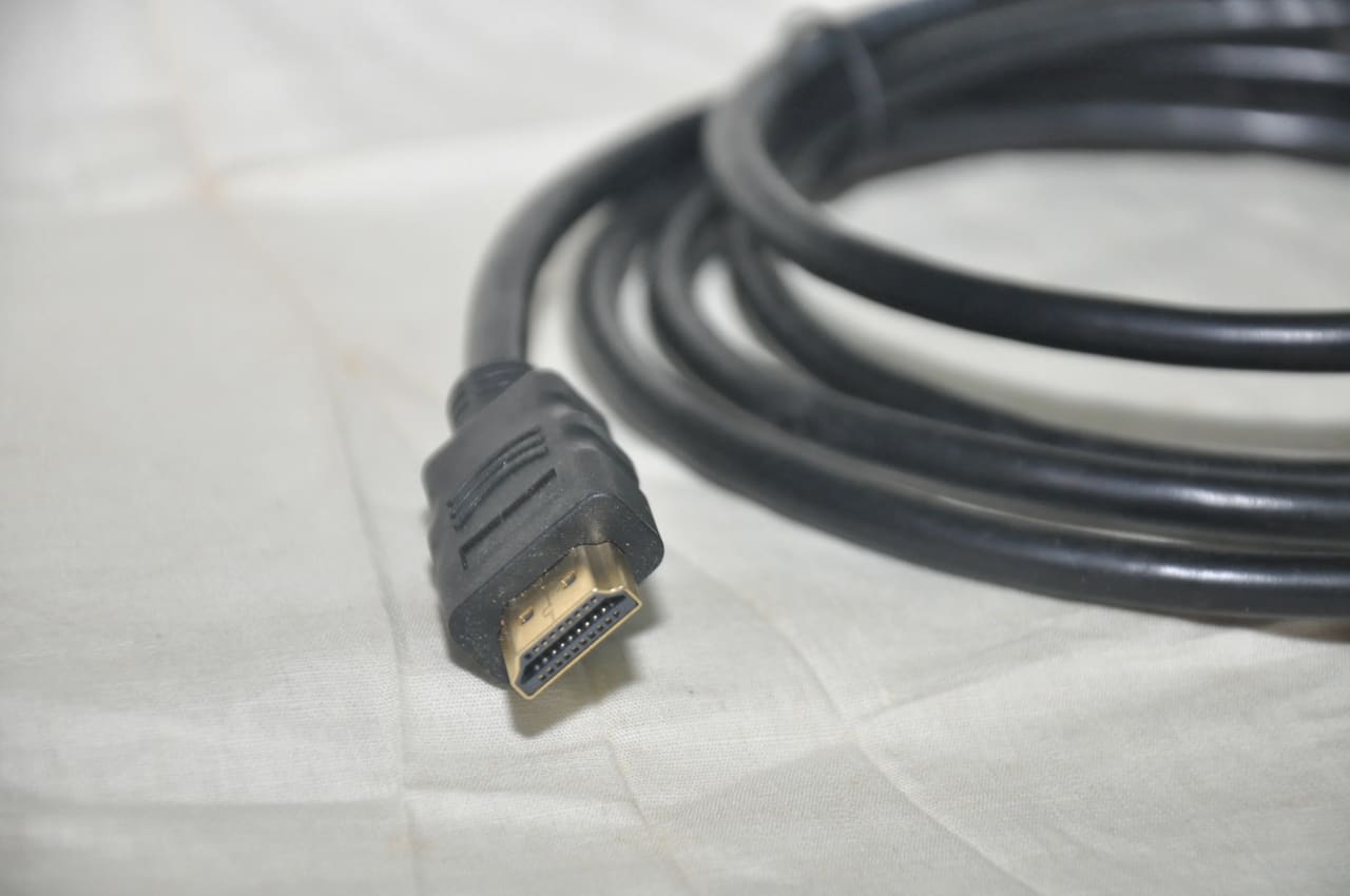 Cabo HDMI sobre uma superfície, usado para representar organização de conexões de vídeo em home theater