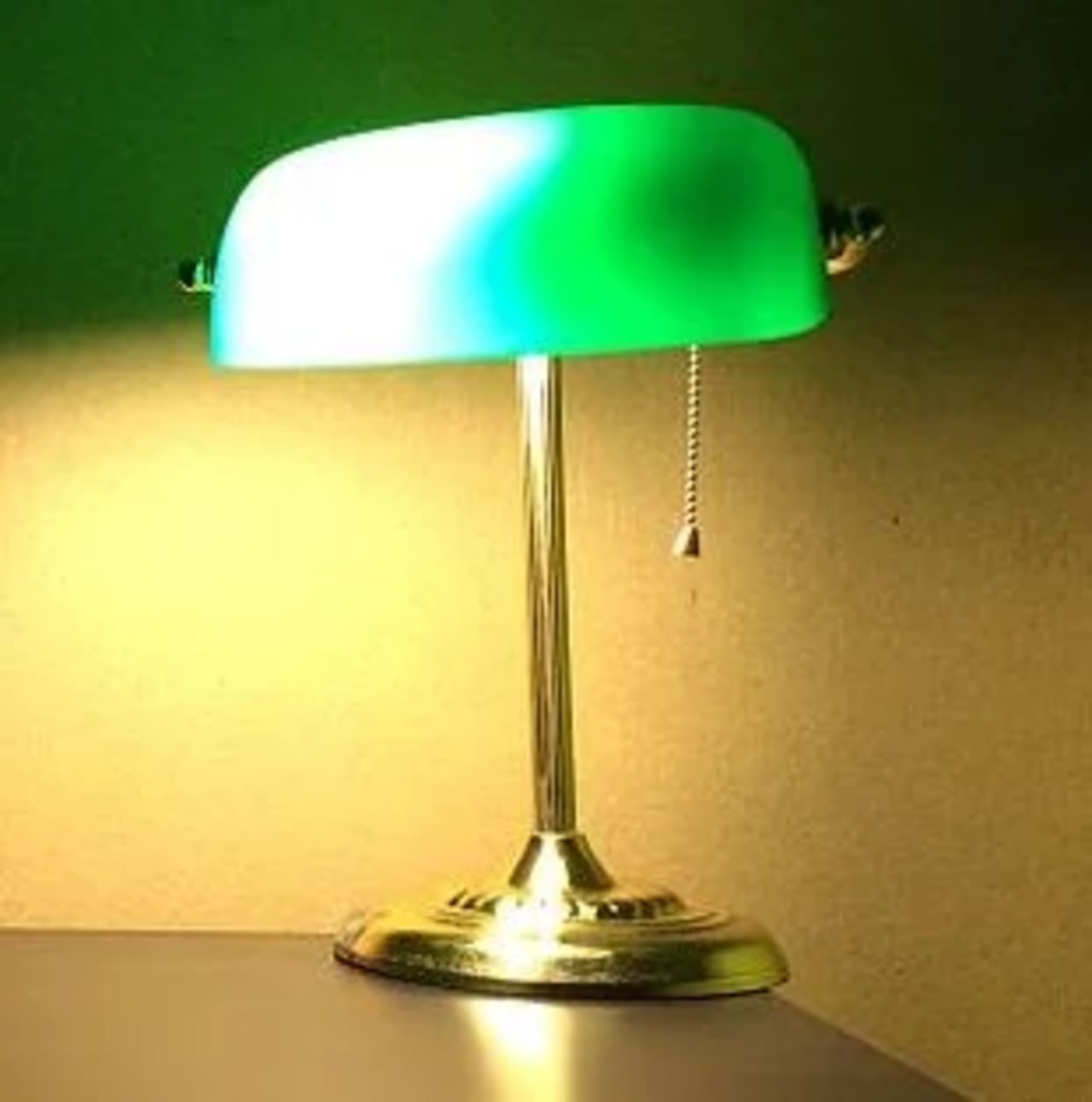Luminária de mesa acesa sobre uma escrivaninha, representando luz para leitura e produtividade