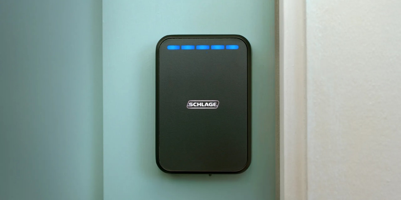 Fechadura Schlage Sense Pro preta instalada em uma porta, com luzes azuis no painel frontal