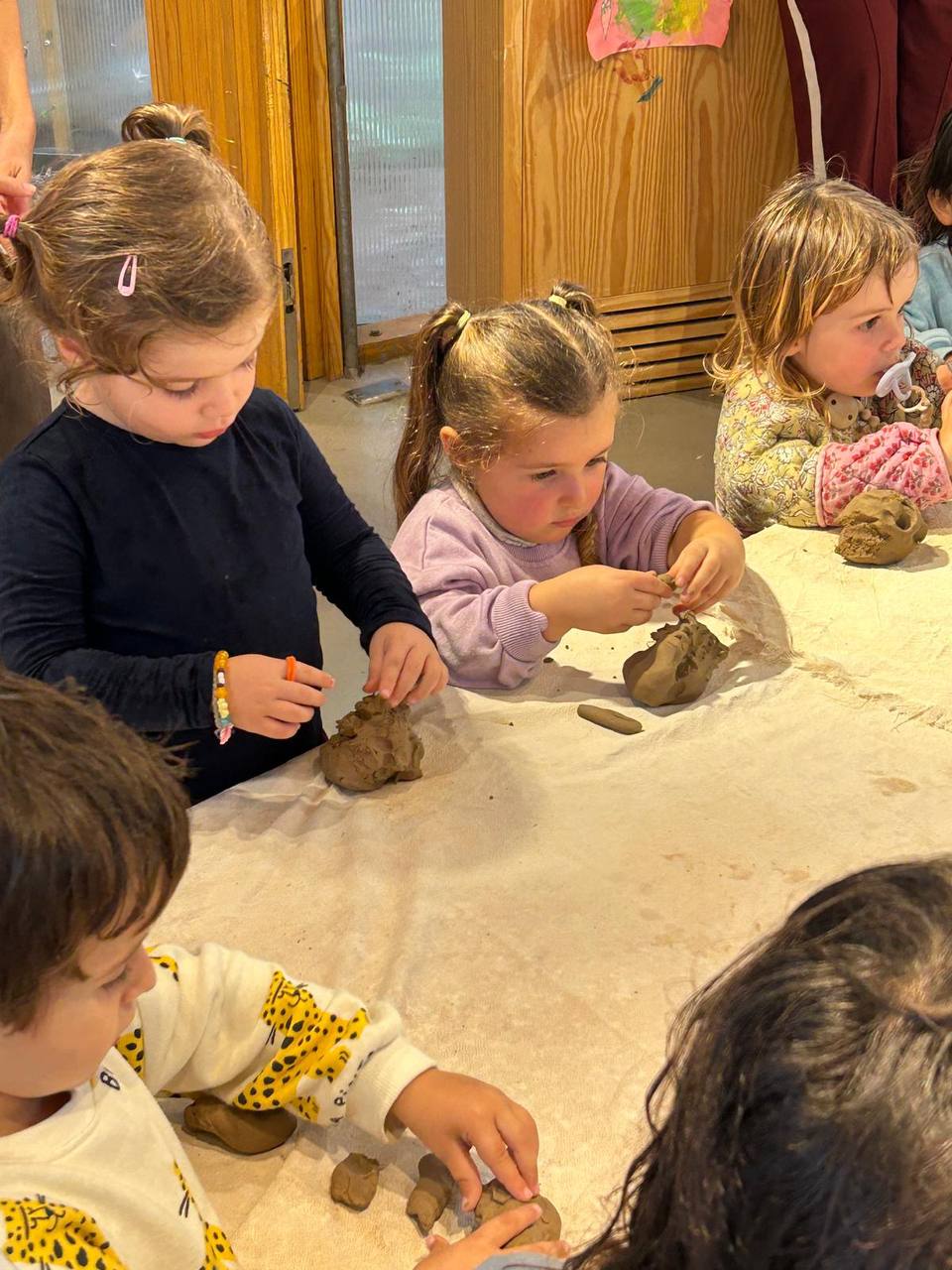 Niños y niñas creando con materiales del bosque