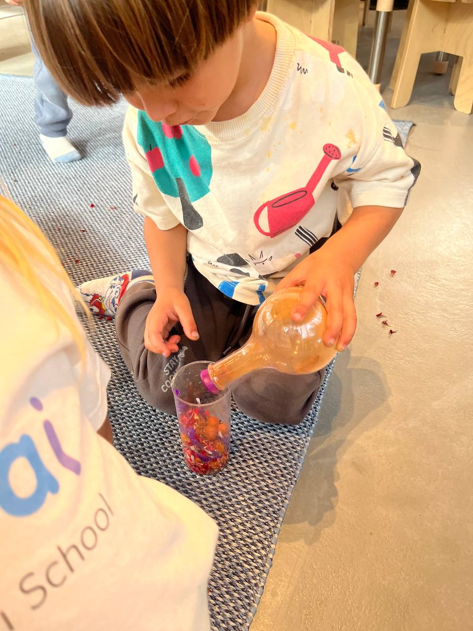 Niños y niñas explorando texturas, colores y elementos naturales con lupas