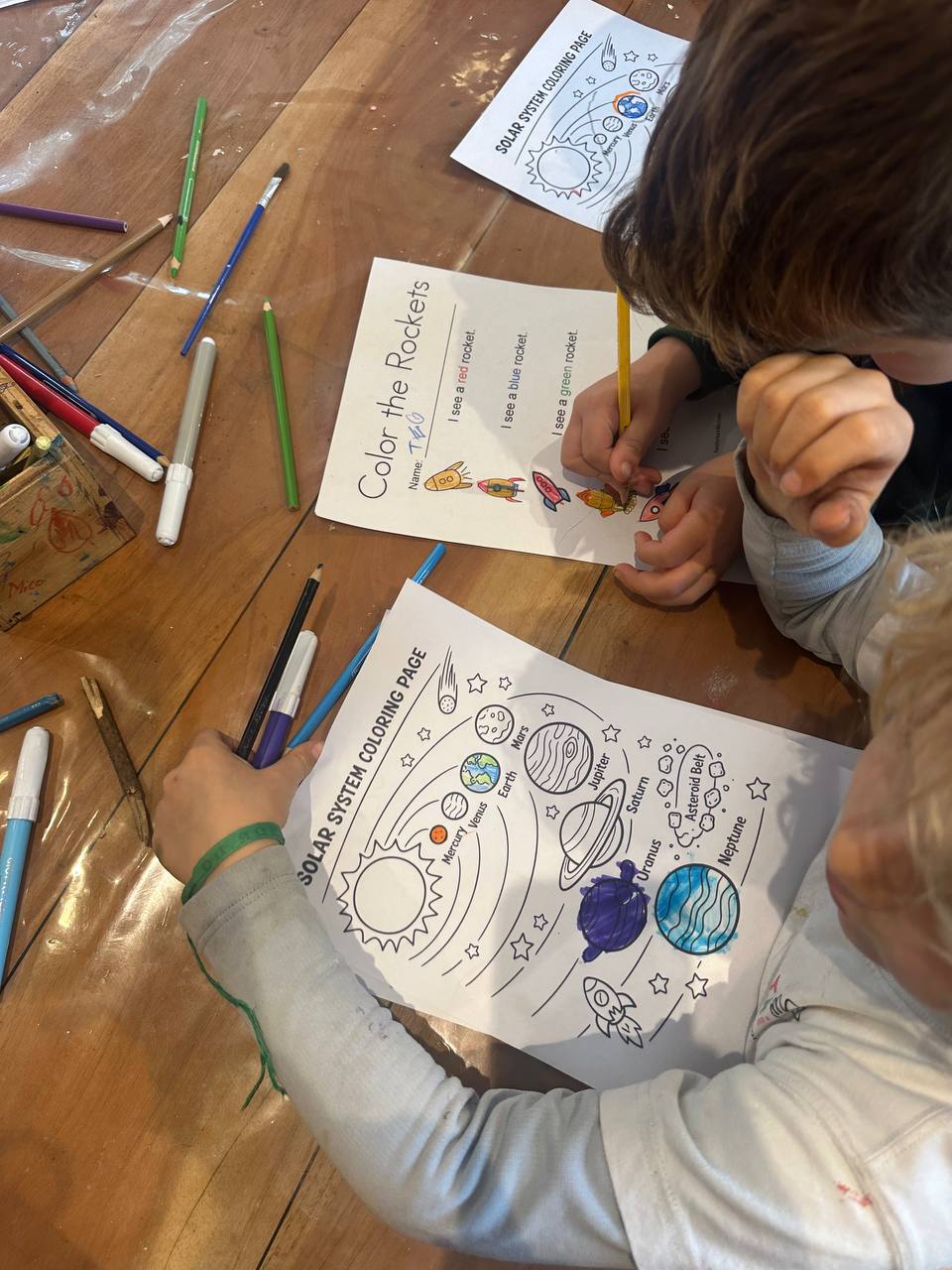 Niños y niñas trabajando con hilo y piezas pequeñas