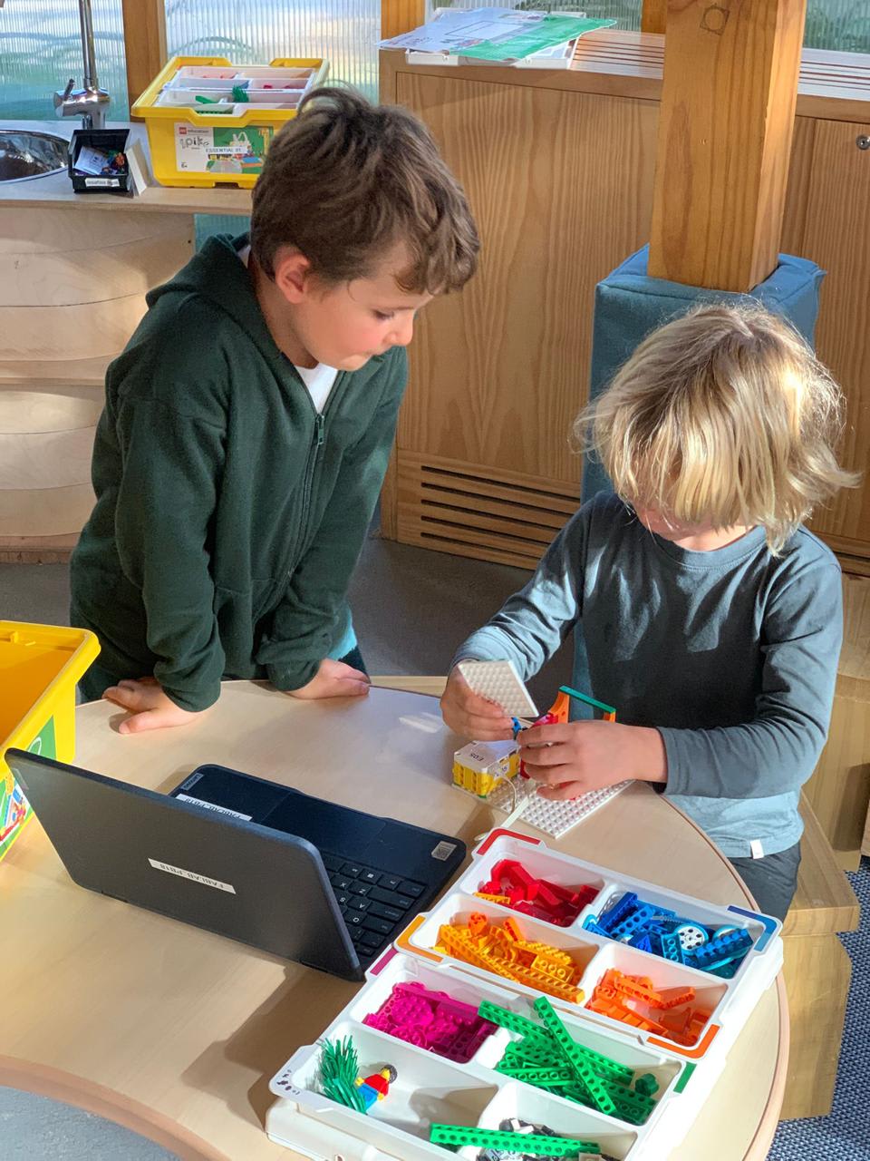 Niños y niñas trabajando en programación con LEGO