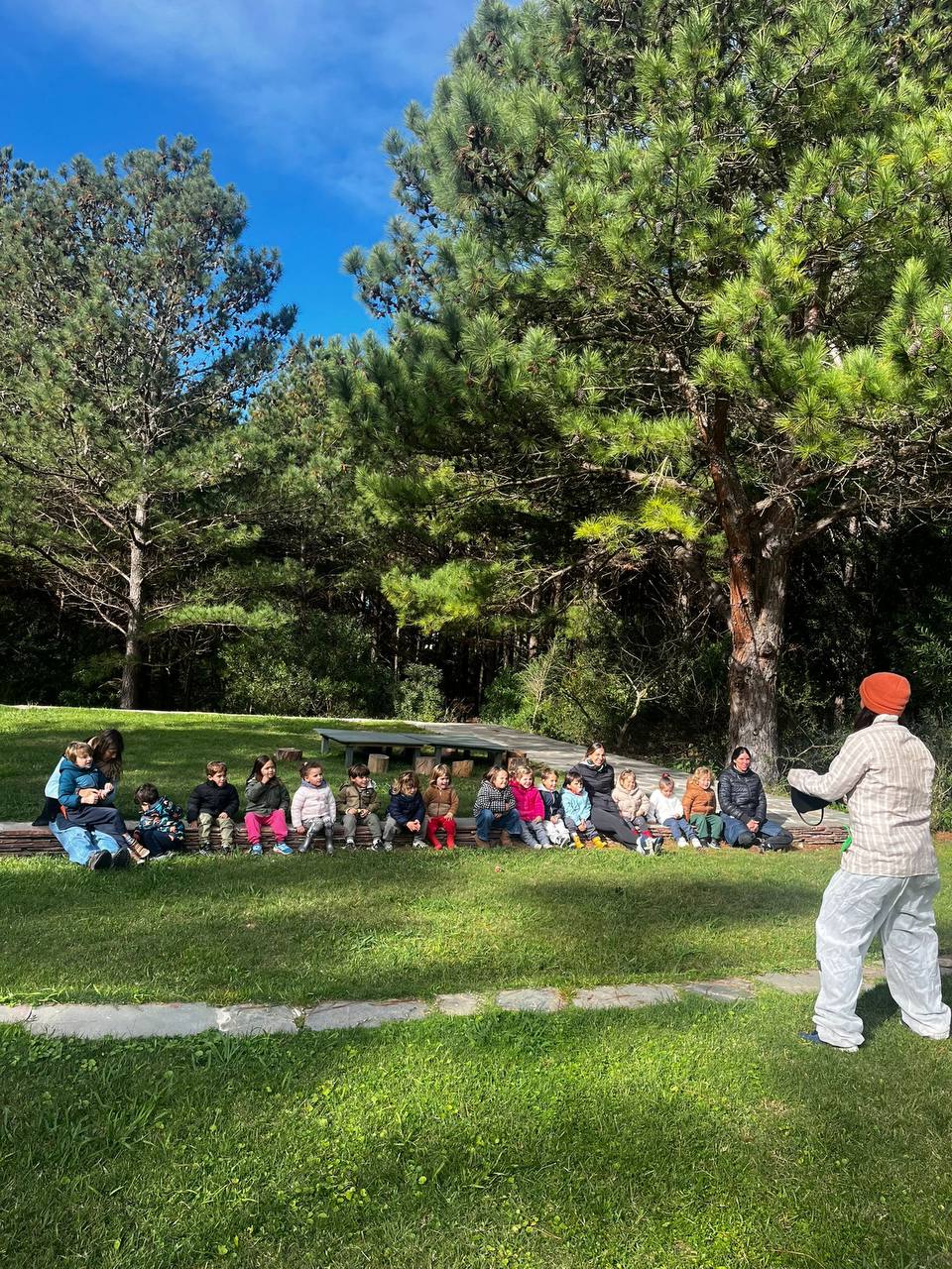 Niños pintando lienzos colgados entre los arboles del bosque