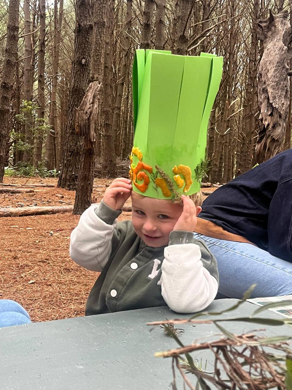 Niño con una corona verde decorada con elementos naturales