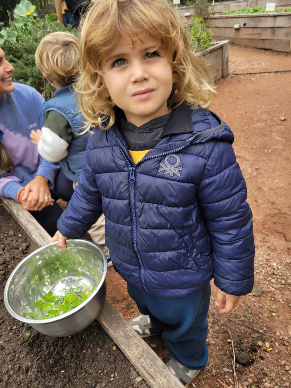 Niño explorando de cerca un ingrediente durante la preparación culinaria