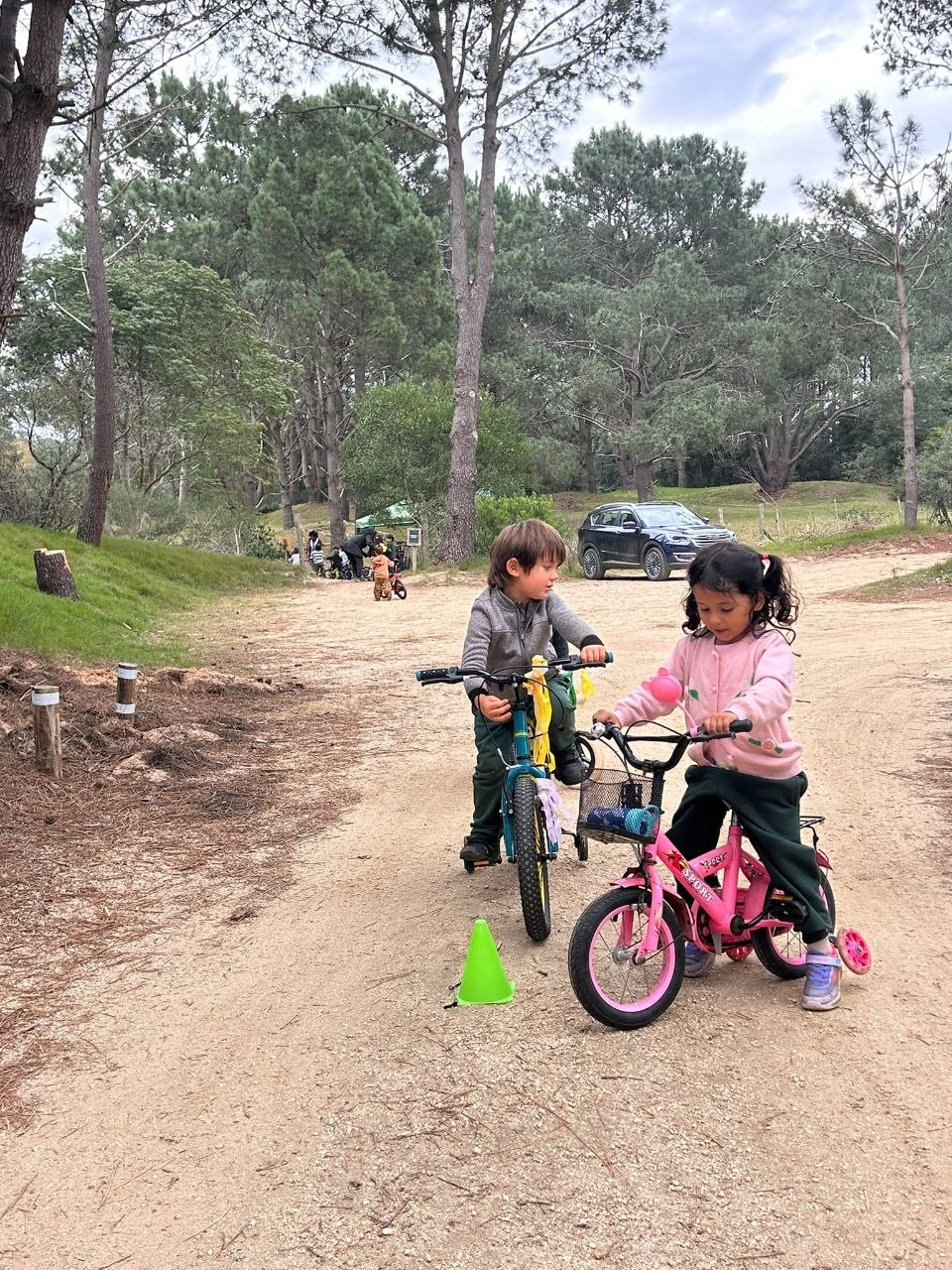 Niños y niñas participando en un circuito de bicicletas y señales de tránsito