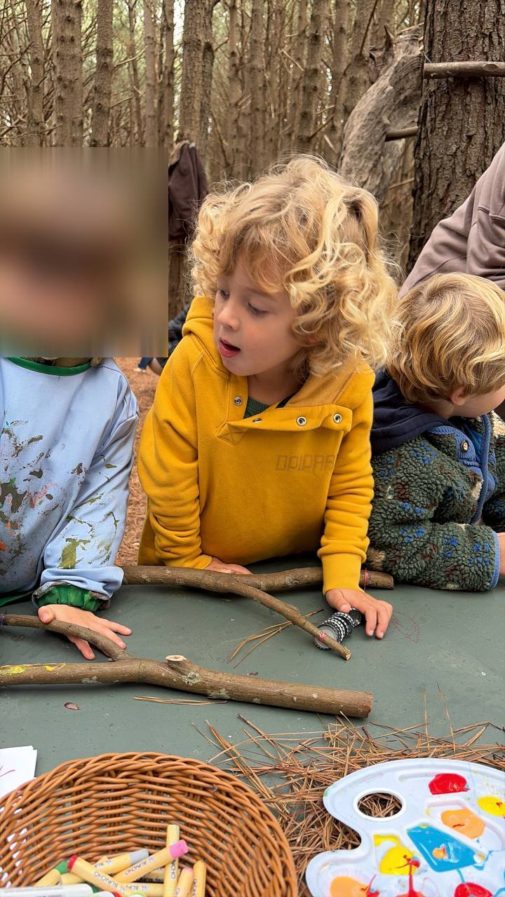 Niños trabajando con ramas e instrumentos naturales sobre la mesa