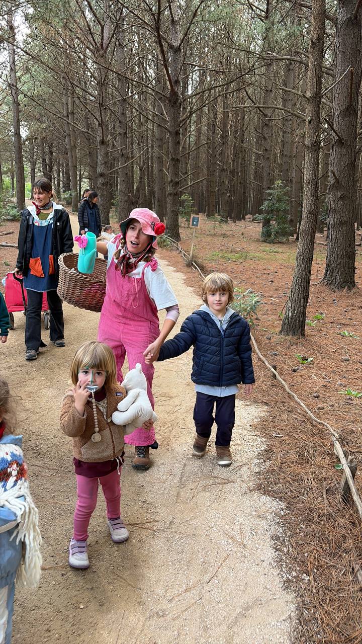 Ninos caminando por un sendero del bosque con sus educadoras