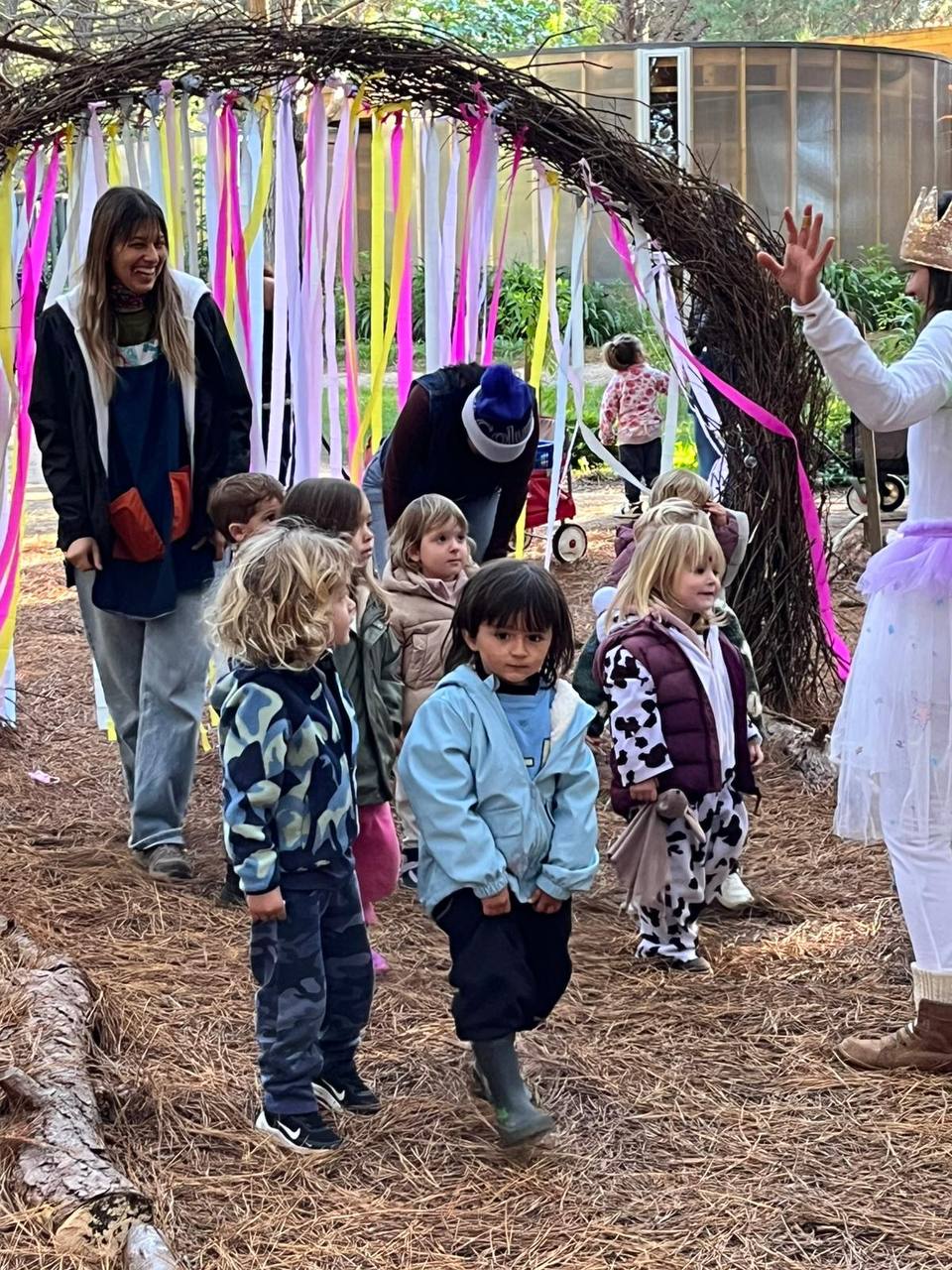 Ninos junto a un hada y un cofre entre los arboles del bosque