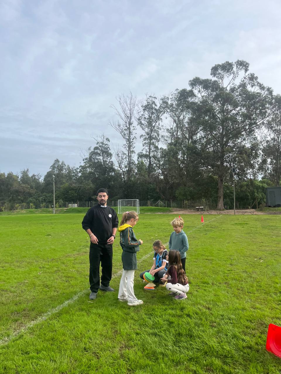 Grupo reunido con materiales de juego durante la actividad en la canchita