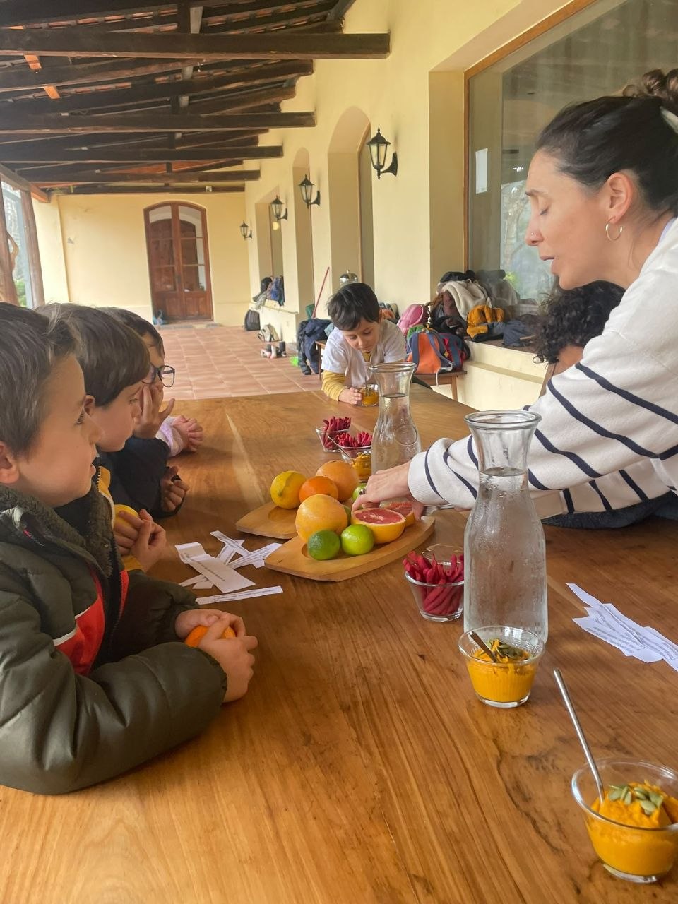 El grupo comparte la mesa de cítricos: observa, prueba y manipula frutas mientras explora el material preparado.