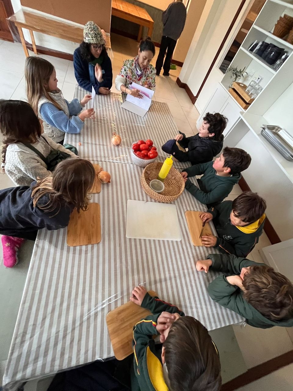 Preparación colectiva de salsa italiana: corte y organización de tomate, cebolla y ajo; condimentos, cocción y trabajo en equipo.