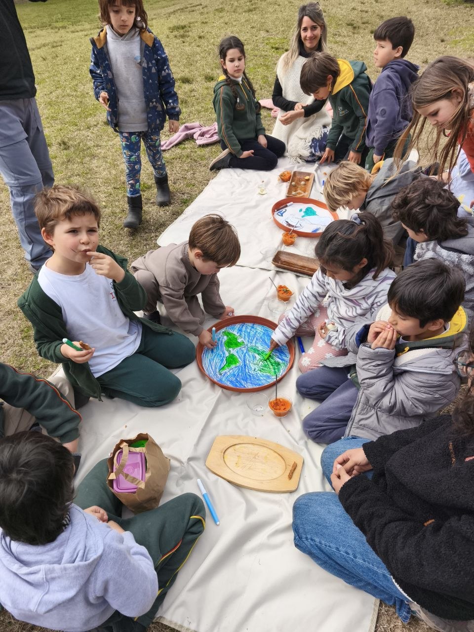 Proceso de creación de las macetas-mapa: el grupo pinta océanos y continentes que acompañarán el crecimiento de los brotes.