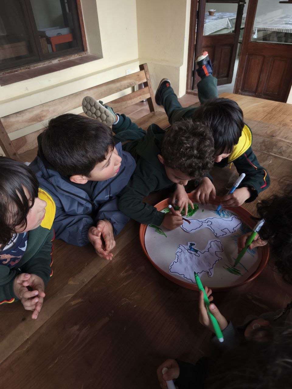 Proceso de creación de las macetas-mapa: el grupo pinta océanos y continentes que acompañarán el crecimiento de los brotes.