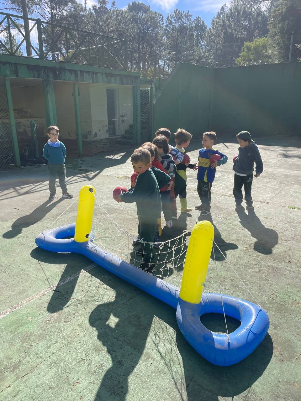 Juegos con pelota y desafío de embocar en el aro, en la cancha de pádel.