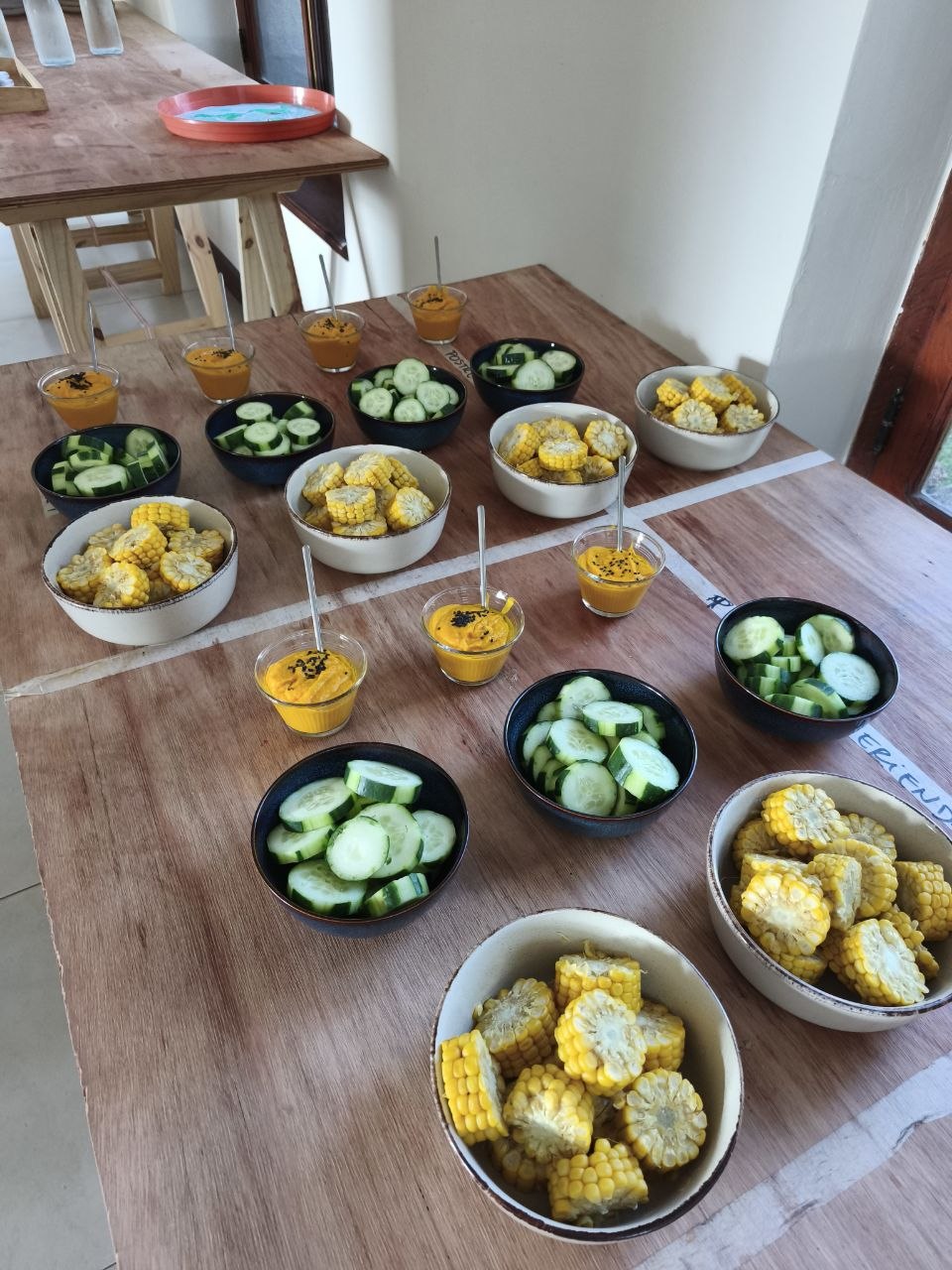 Fiesta de pizzas: mesa de ingredientes para armar, frutas y encuentro compartido en la mesa.