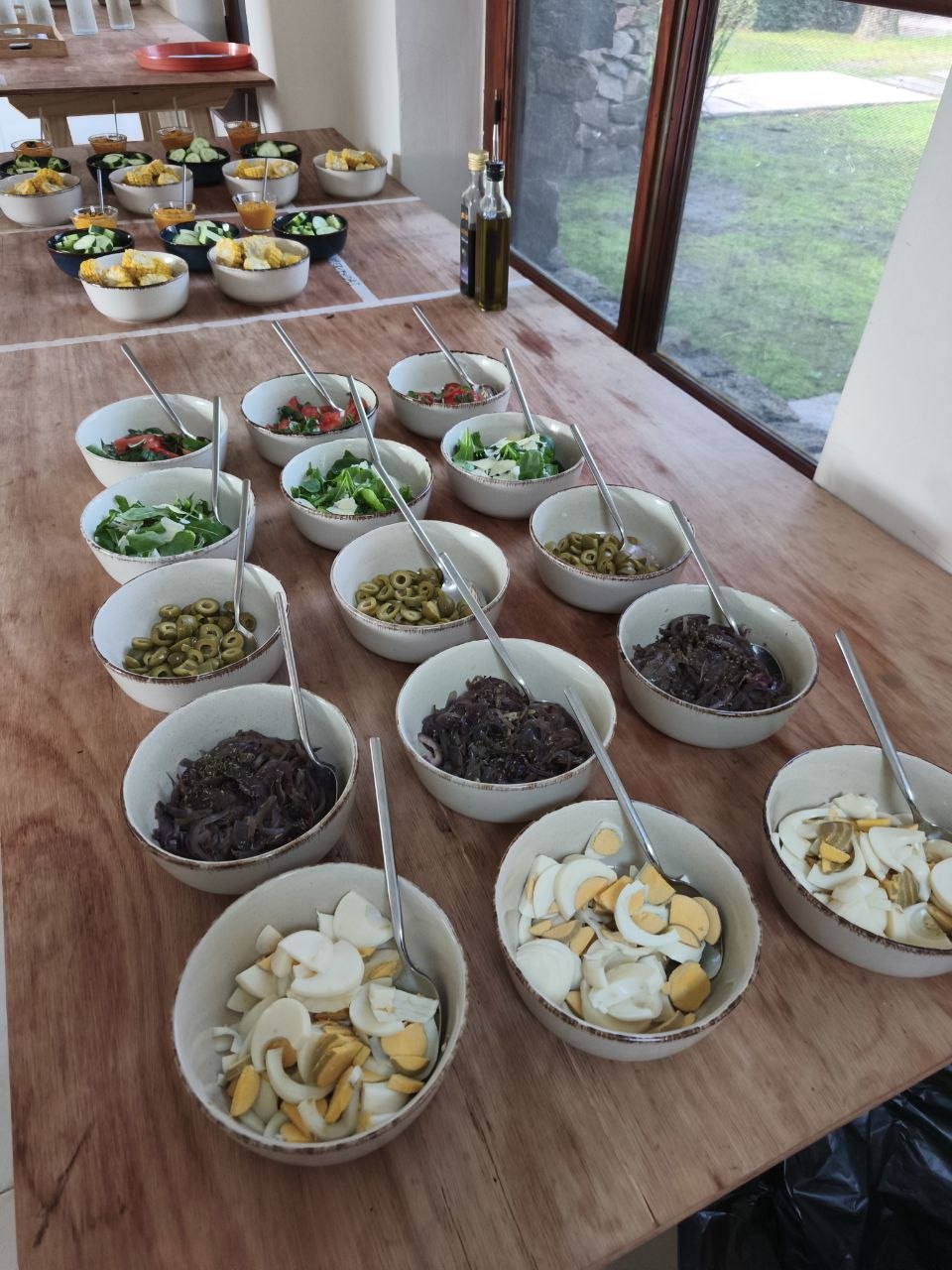 Fiesta de pizzas: mesa de ingredientes para armar, frutas y encuentro compartido en la mesa.