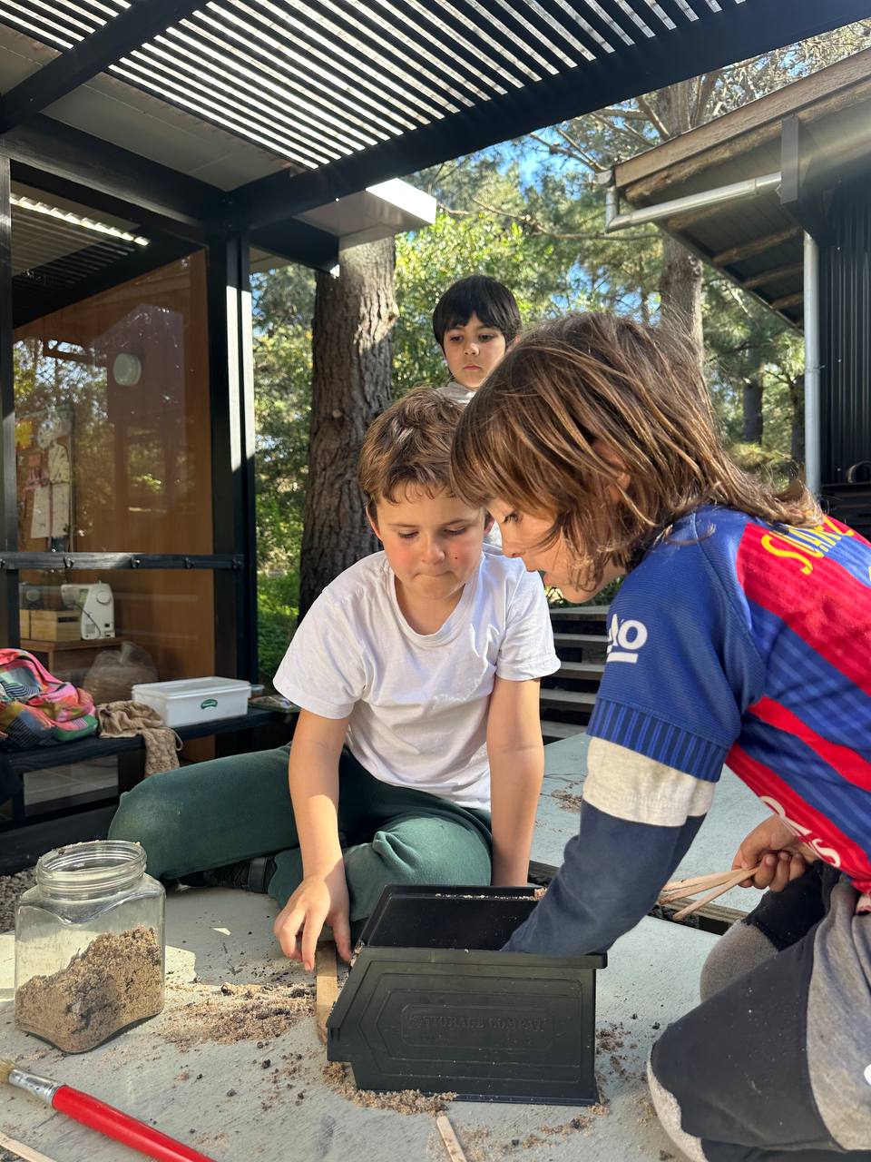 Los niños crean hormigas y hormigueros con arcilla, hojas, ramitas y otros elementos de la naturaleza para el libro colectivo.