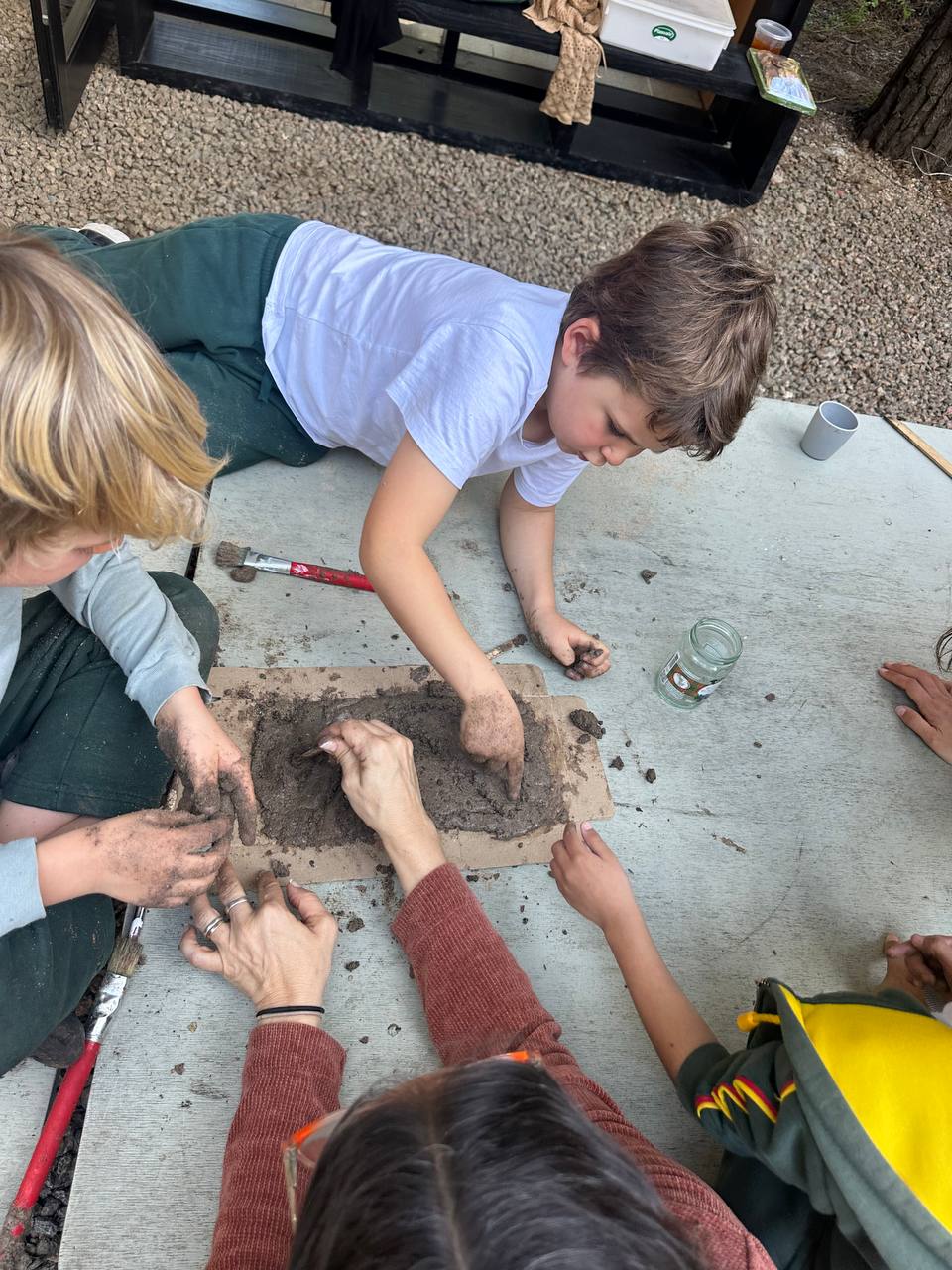 Los niños crean hormigas y hormigueros con arcilla, hojas, ramitas y otros elementos de la naturaleza para el libro colectivo.