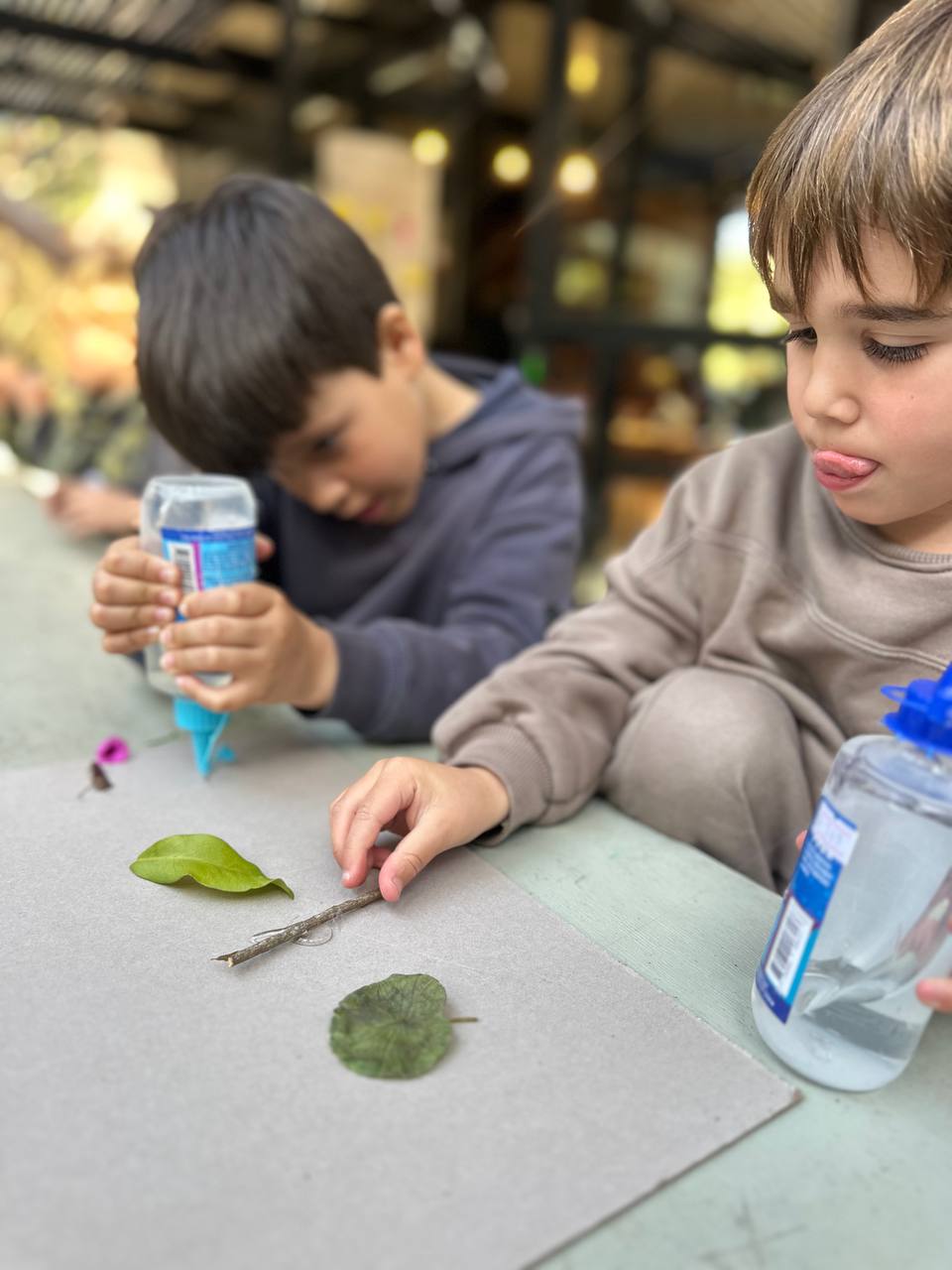 Los niños crean hormigas y hormigueros con arcilla, hojas, ramitas y otros elementos de la naturaleza para el libro colectivo.