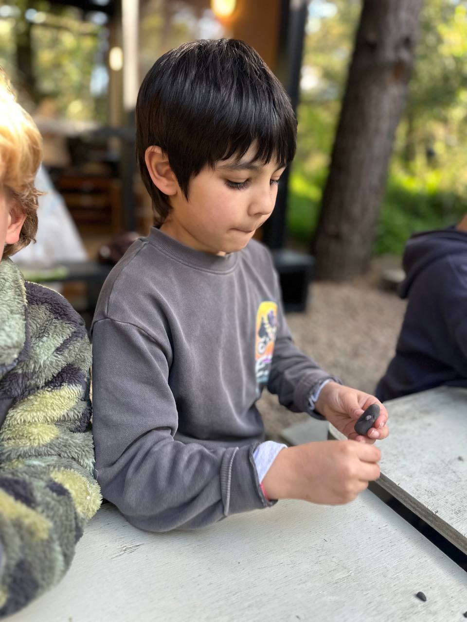 Los niños crean hormigas y hormigueros con arcilla, hojas, ramitas y otros elementos de la naturaleza para el libro colectivo.