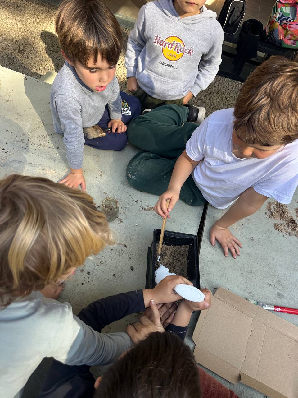 Los niños crean hormigas y hormigueros con arcilla, hojas, ramitas y otros elementos de la naturaleza para el libro colectivo.